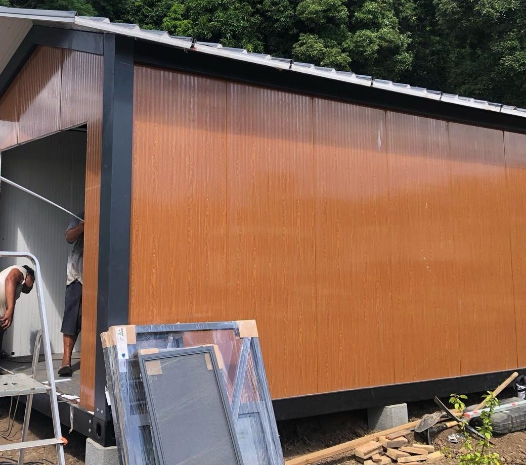 Deux poseurs installent les menuiseries d'un module